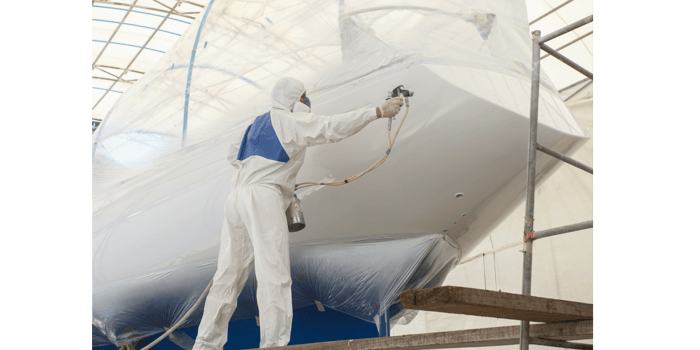 Person painting the hull of a boat