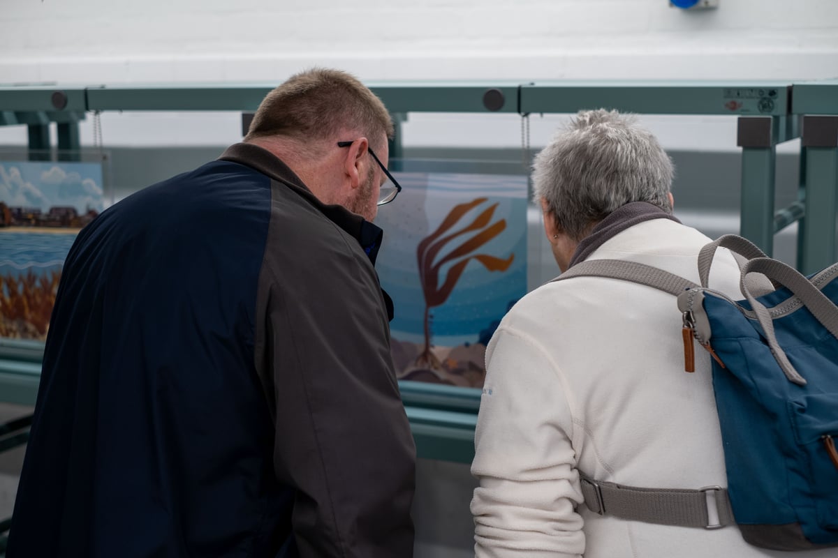 two people looking at sea-based artwork