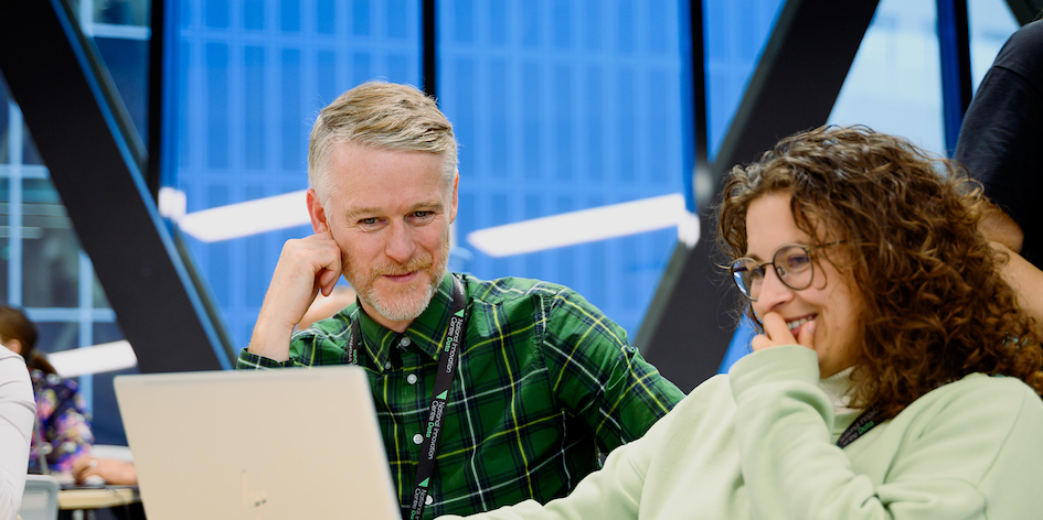 Two people working together on a laptop