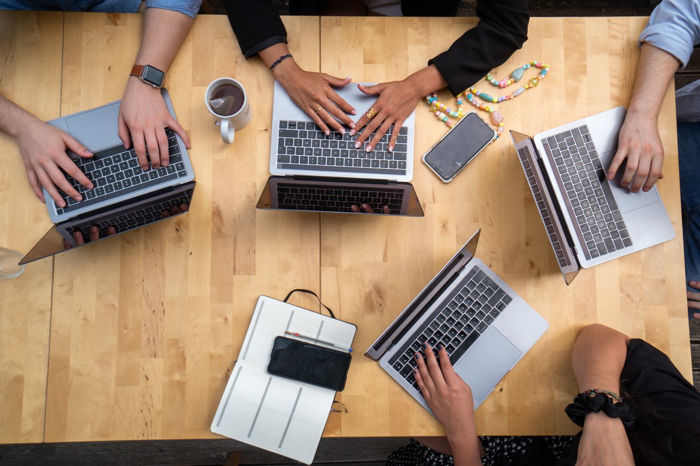 bird's eye view of four individuals working on laptops